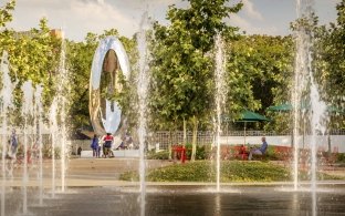 Outdoor image of water fountains coming out of the ground and shooting into the air