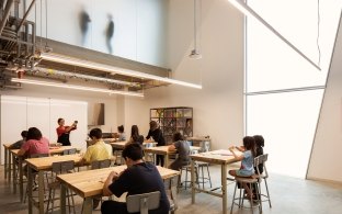 Indoor classroom with a board and desks that students are sitting at