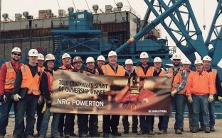 Image of smiling workers holding a banner to celebrate winning the spirit of ownership award