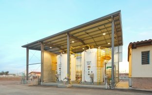 External tanks at the water reclamation facility sit under a roof in an otherwise open-sided building.