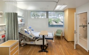 Indoor image of a patients room with the bad and bathroom