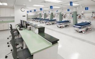 Indoor image of the nurses station and rows of beds with cloth dividers 