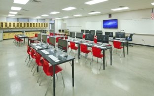 Classroom with chairs and desks facing white board and TV monitor