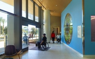 Interior entrance of the building with people walking through the front doors