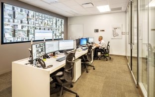 Indoor image of three decks in front of a wall of security cameras