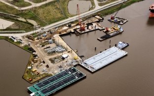 Aerial view of the barge docks during construction with water in the foreground of the photo