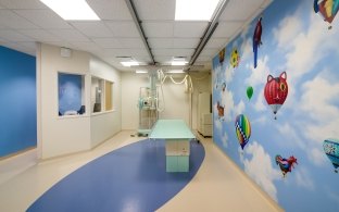 A patient room with hot air balloon wall art