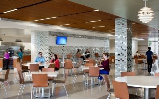 Indoor modern cafeteria with people sitting at tables