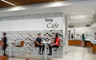 Indoor entrance to a modern cafe with tall tables and chairs