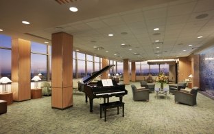 Open lobby area with comfortable seating and a grand piano in the middle