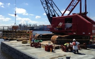 A crane on a barge in the water during construction