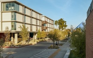 Exterior view of the student housing facility with a sidewalk in front