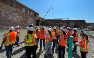 A group of people wearing construction PPE on a jobsite tour.