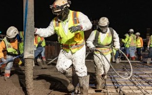 A group of people working on a concrete pour at night