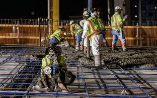 Group of people working on a concrete pour at night