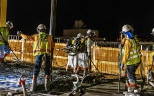 Group of people working on a concrete pour at night