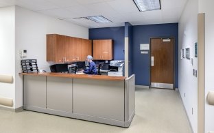 A nurse's station with someone sitting and looking at a computer