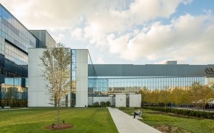 Exterior view of the VA hospital building with a walking path in the forefront of the image