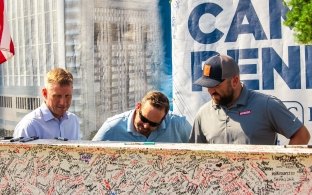 people signing a beam at a topping out ceremony