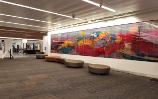 A seating area with a colorful mural on the wall