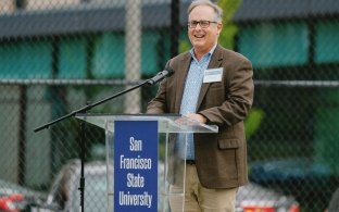 A person giving a speech while standing at a podium