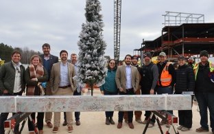 A group of people posing with the final beam