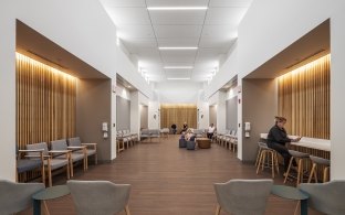 A few people sitting in chairs in the waiting room area