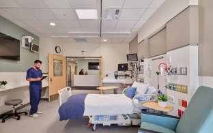 A person standing in a patient room in the hospital