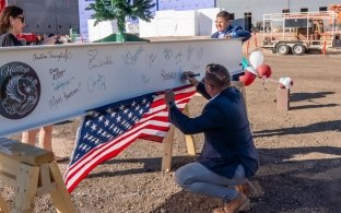 People signing a beam