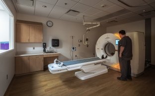 A person standing next to medical imaging equipment