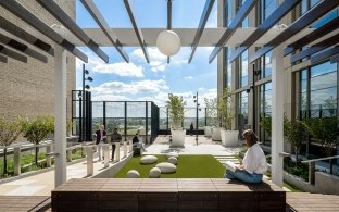 Rooftop healing garden with people walking, sitting, and reading under a modern pergola