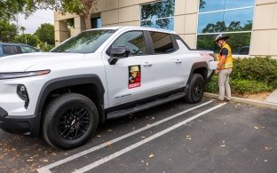A person using a charger on an electric vehicle