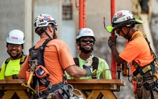 Four people wearing PPE working together on a jobsite