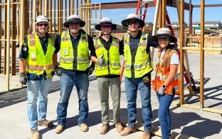 A group of five people wearing PPE on a jobsite