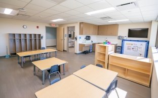 A classroom with multiple tables and chairs