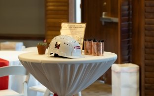 A table with a sign and construction helmet on it