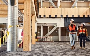 Two people wearing PPE walking through a jobsite