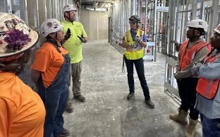 A group of people wearing PPE and talking while on a jobsite