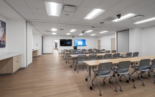 A large room with a few rows of tables and chairs