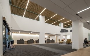 An open area with tall ceilings to the second floor, with desks on the far side