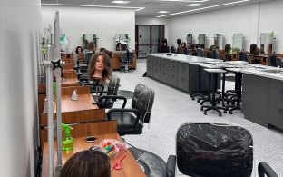 A cosmetology classroom with multiple salon chairs, wigs, and supplies