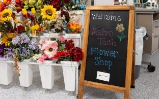 A welcome sign next to some flowers