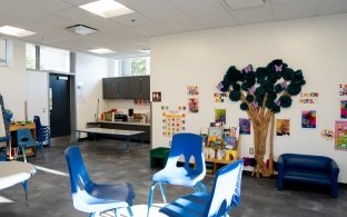 A childcare facility with chairs, tables, and various wall decor