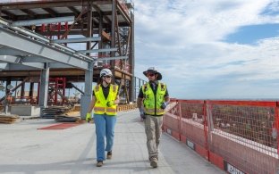 Two people walking on a jobsite wearing PPE