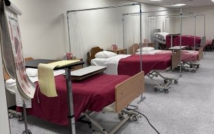 A nursing program classroom with patient beds and various supplies
