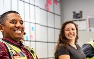 Three people sitting at a table and smiling
