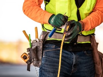 Person using tape measure. 