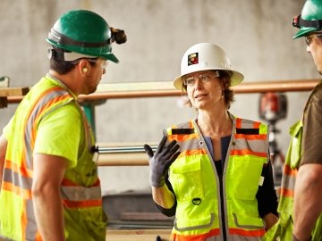 3 people at a jobsite talking to each other.