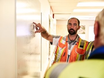 Person pointing to a white board.