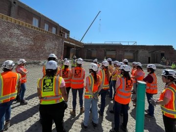 A group of people wearing construction PPE on a jobsite tour.